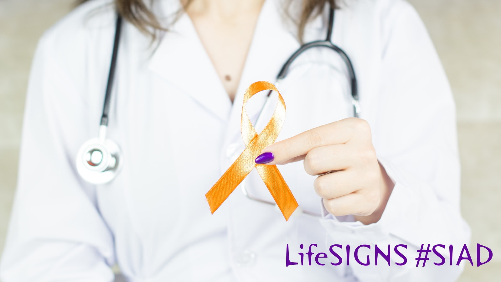 A nurse or doctor in a white coat holds an orange awareness ribbon.